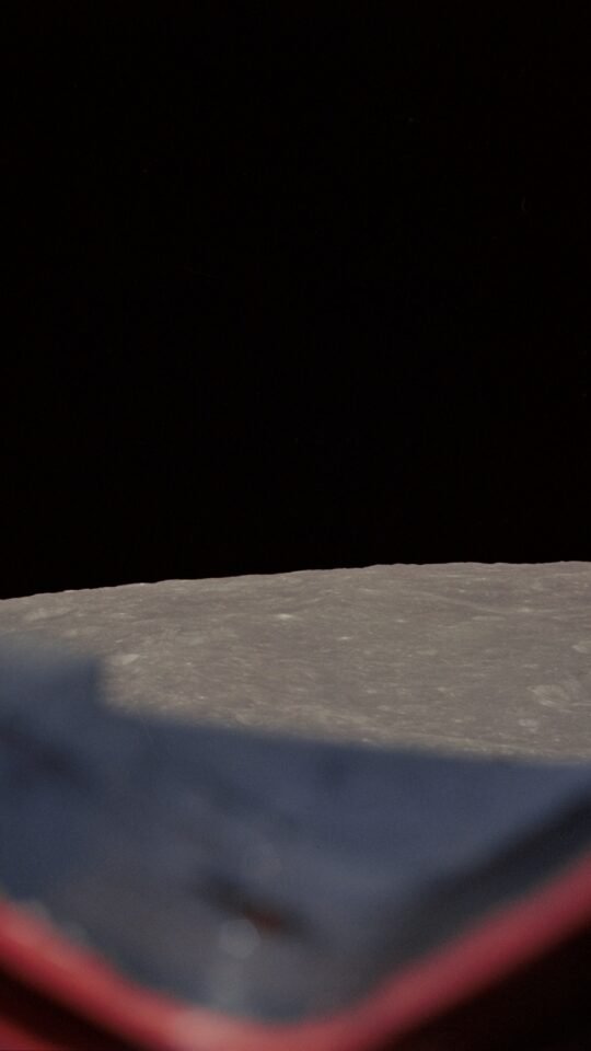 Earth rising above the Moon's gray horizon during Apollo 8