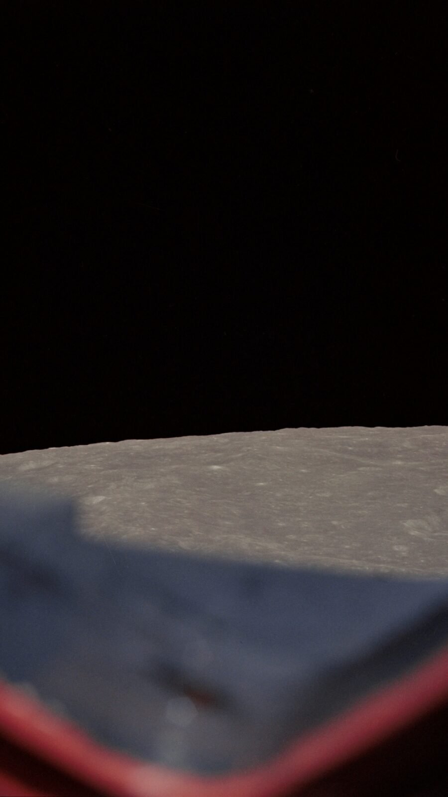 Earth rising above the Moon's gray horizon during Apollo 8