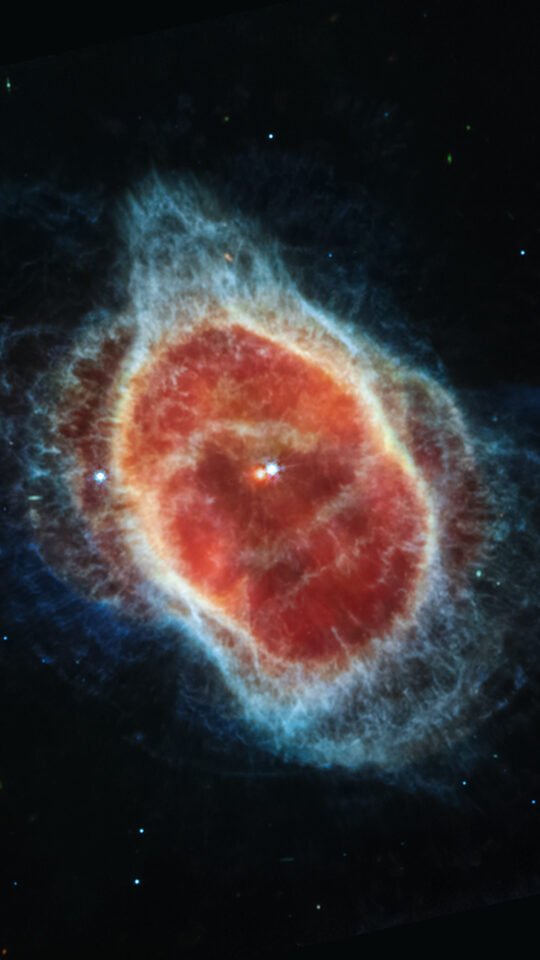 Red and blue shell of the Southern Ring Nebula against black space